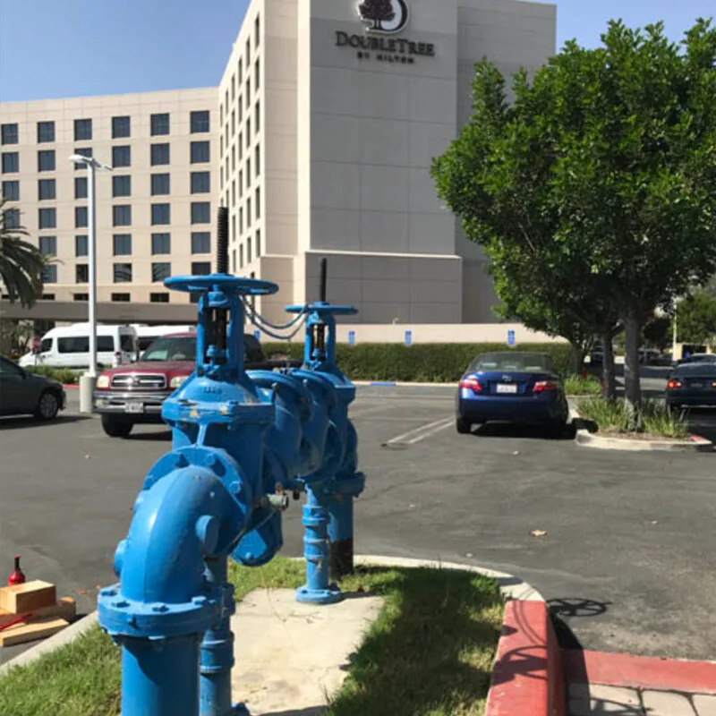 A Smart Valve installed on blue exterior pipework outside a hotel