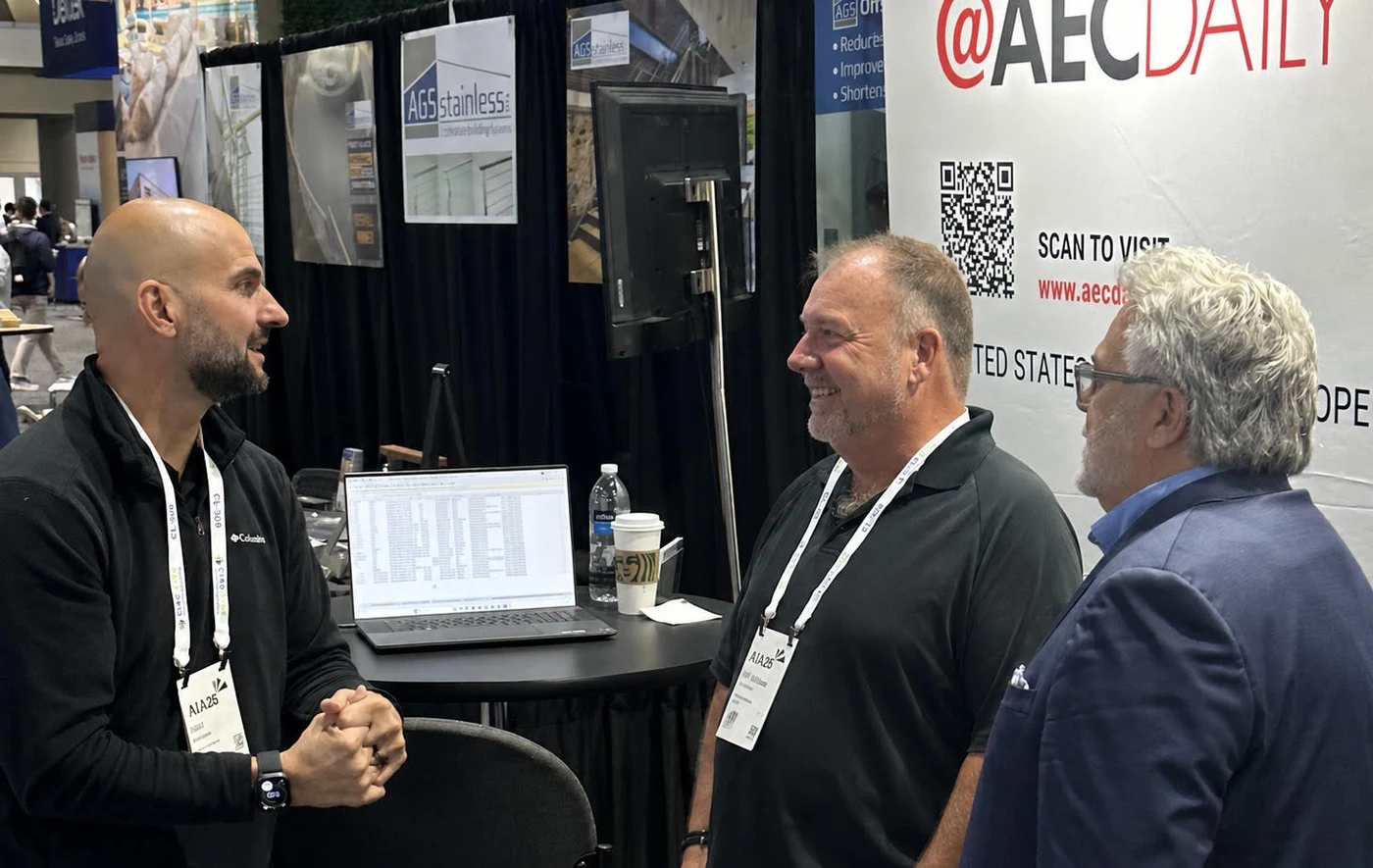 Three industry professionals in conversation at an AIA convention booth, the kind of direct human exchange tect is built around